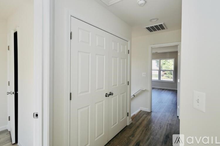 A white door with a black handle is in a room with a window.