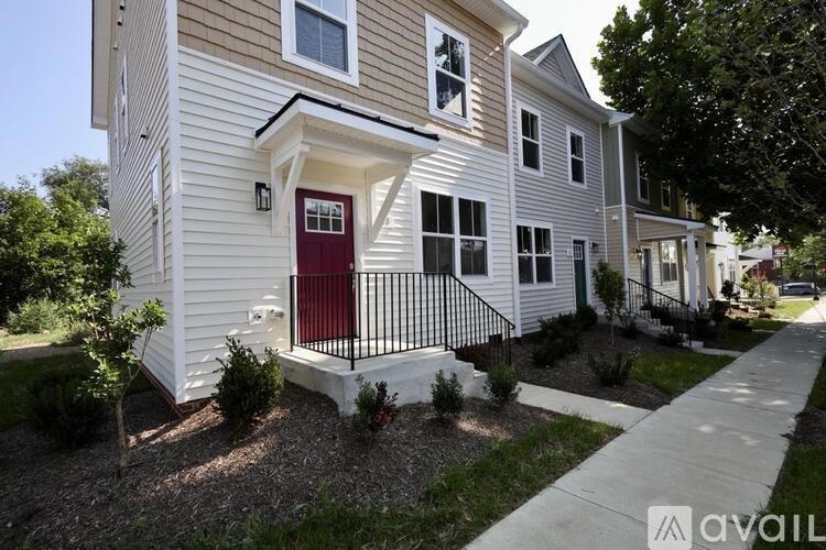 A two-story house with a red door and a balcony.