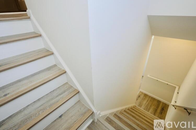 A wooden staircase with a white wall on the side.