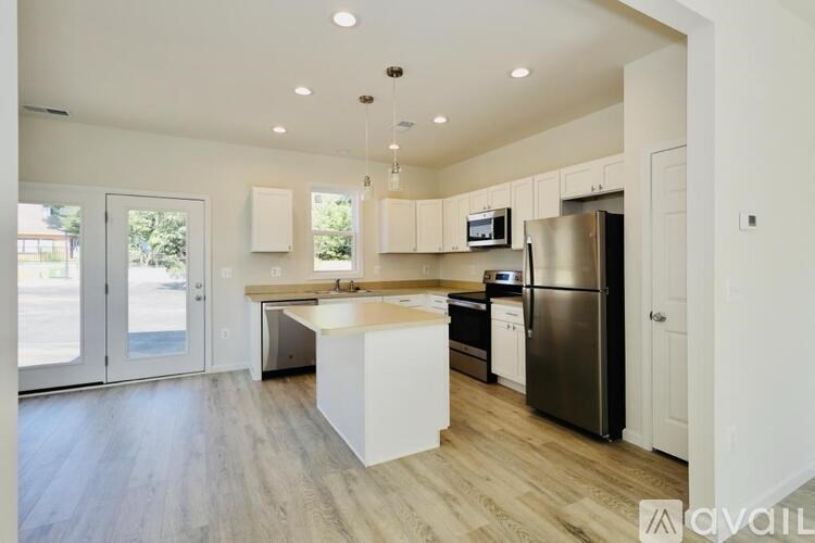 A kitchen with a refrigerator, microwave, and oven.
