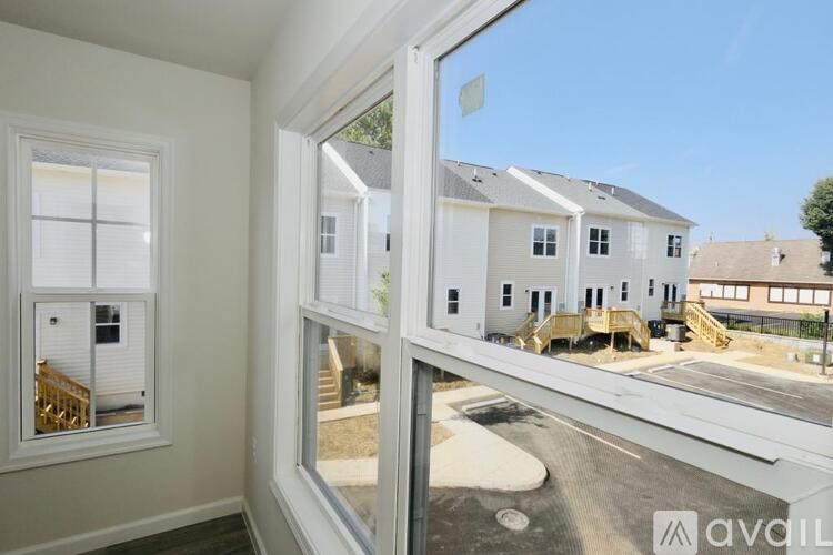 A view from inside a room looking out through a window at a residential area.