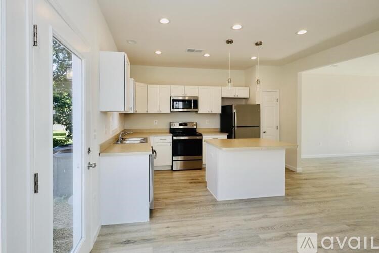 A modern kitchen with white cabinets and a wooden island.