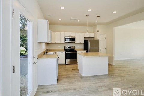 A modern kitchen with white cabinets and a wooden island.