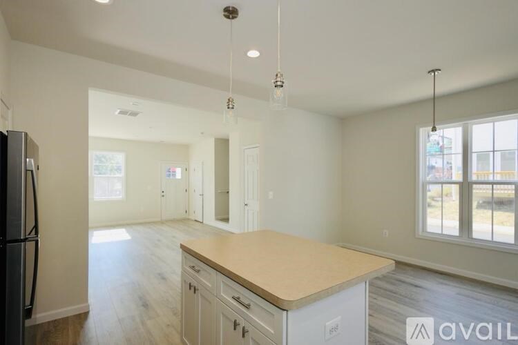 A kitchen with a wooden counter top and white cabinets.