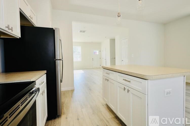 A kitchen with black appliances and white cabinets.