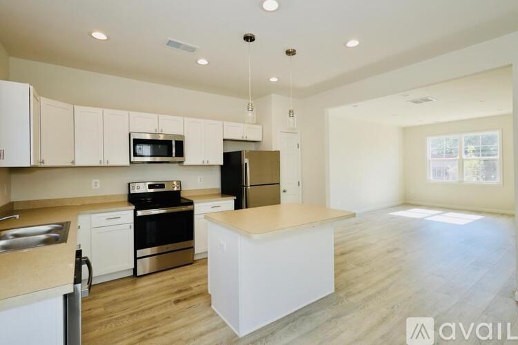 A kitchen with white cabinets and a wooden island.