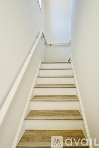 A flight of stairs with wooden treads and white risers.