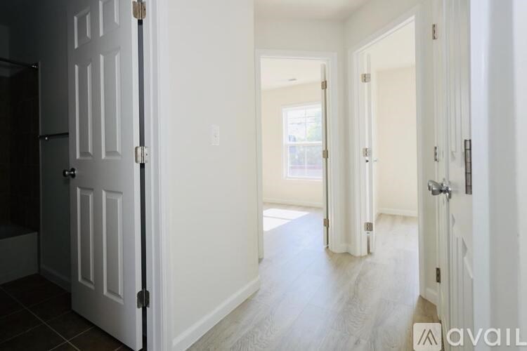 A hallway with white doors and a wooden floor.
