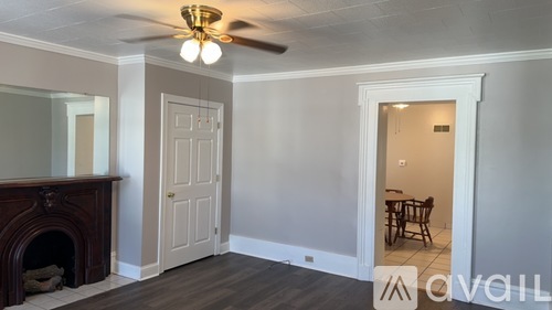 A room with a fireplace and a ceiling fan.