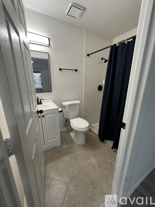 A bathroom with a toilet, sink, and shower.