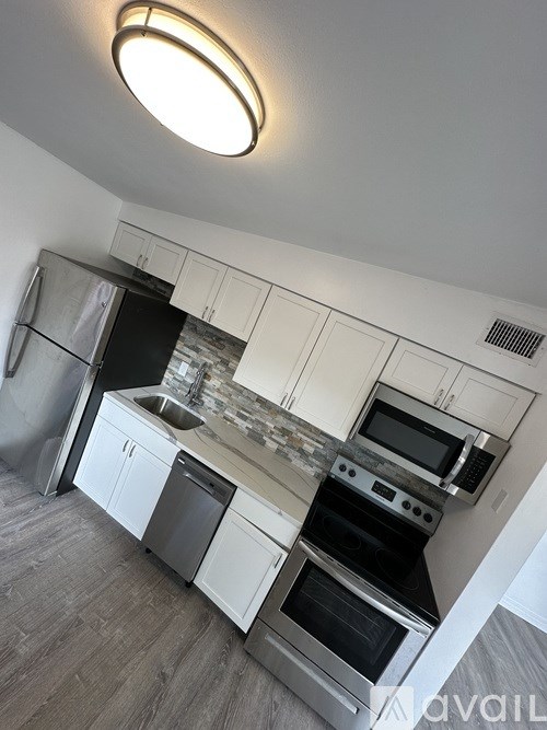 A kitchen with white cabinets and stainless steel appliances.