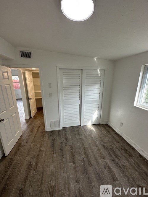 A room with a wooden floor and a white door.