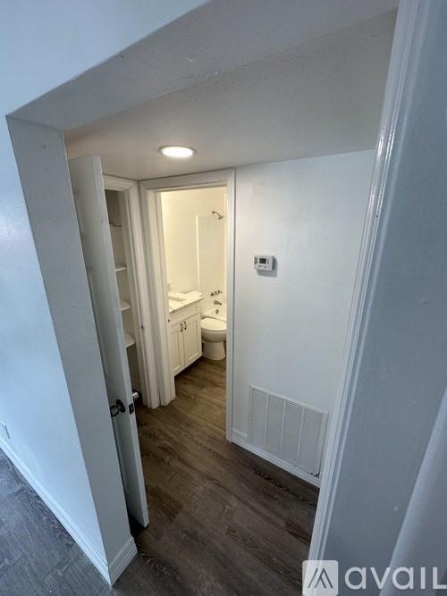 A bathroom with a toilet, sink and mirror.