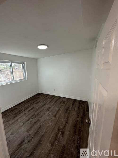 A room with wooden flooring and a window.