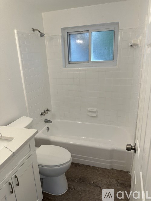 A white bathroom with a toilet, sink, and bathtub.