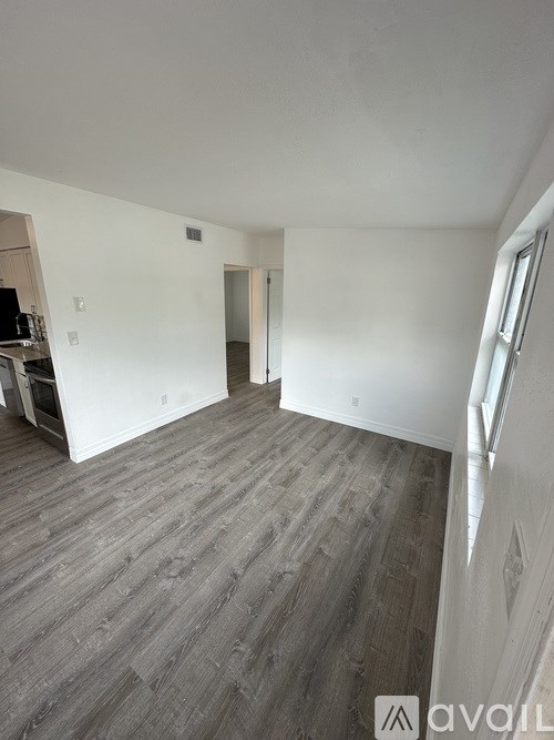A room with wooden flooring and white walls.