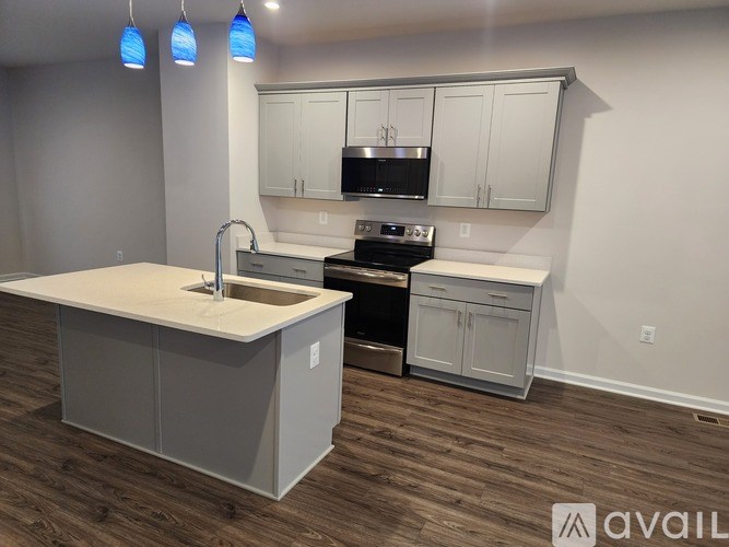 A kitchen with a white countertop and grey cabinets.