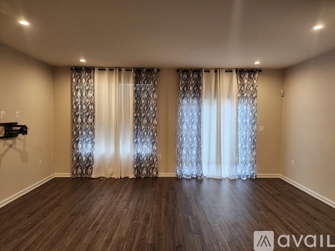 A room with wooden floors and patterned curtains.