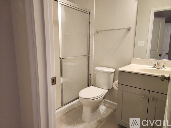A bathroom with a toilet, sink, and shower.