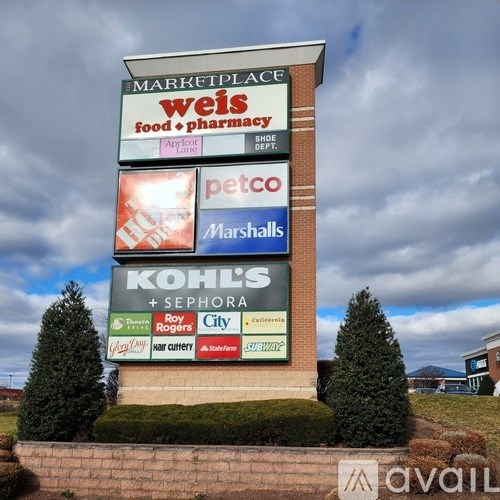 A sign for a marketplace with various stores including Weis, Petco, Marshalls, and Kohl's.