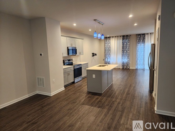 A spacious kitchen with wood flooring and modern appliances.