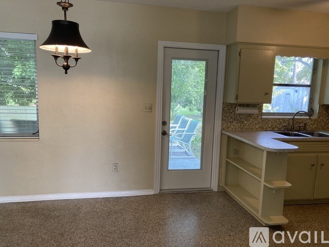 A kitchen with a sink, cabinets, and a window.