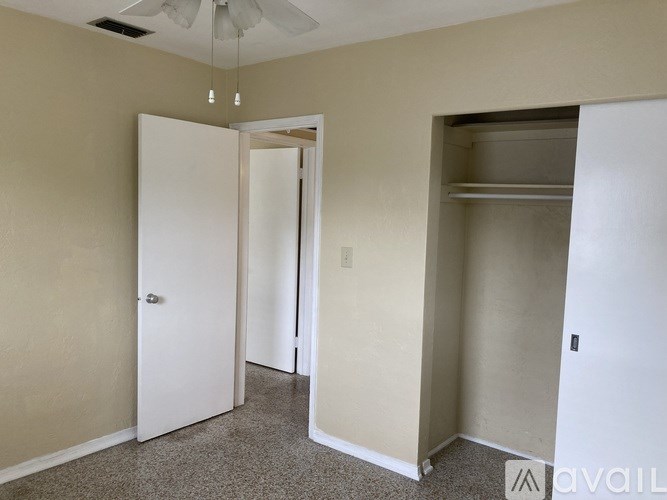 A room with a ceiling fan and two doors, one of which is open.