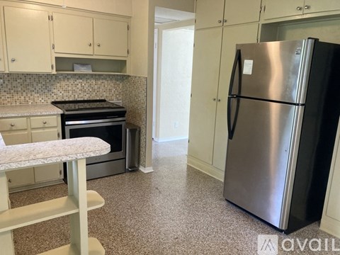 A kitchen with a stove top oven and a refrigerator.