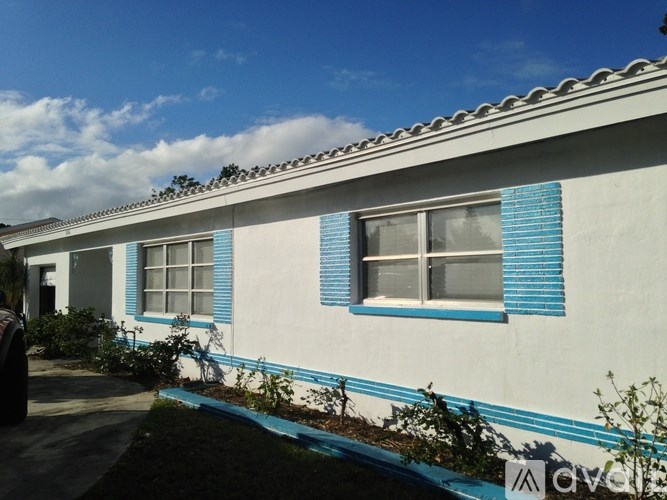 A white house with blue trim and shutters.