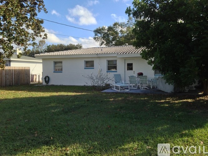 A white house with a tiled roof and a wooden fence.