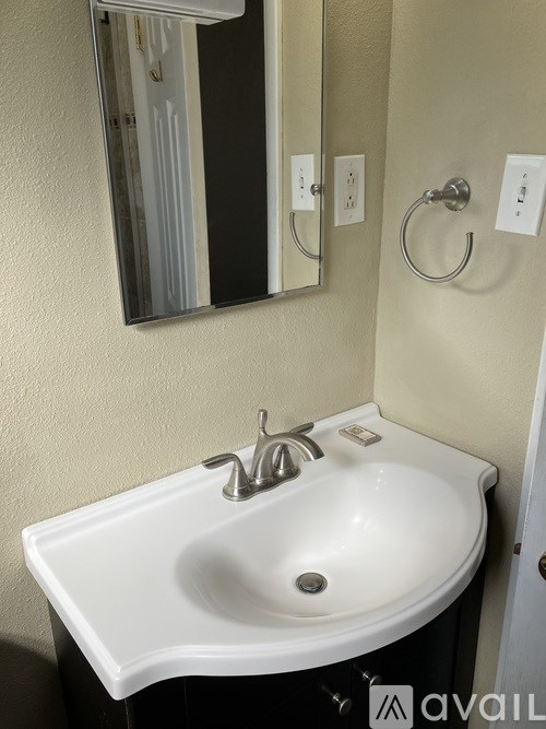 A white sink in a bathroom with a mirror above it.