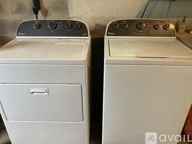 Two white washing machines are side by side.