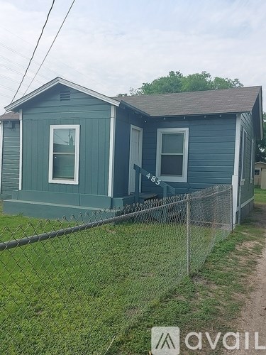 A blue house with a fence in front of it.