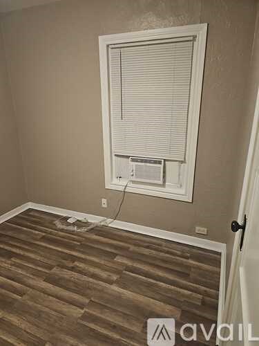 A room with a window and wooden flooring.