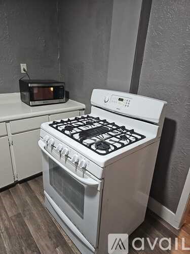 A white door with a black handle is in a room with wooden flooring.