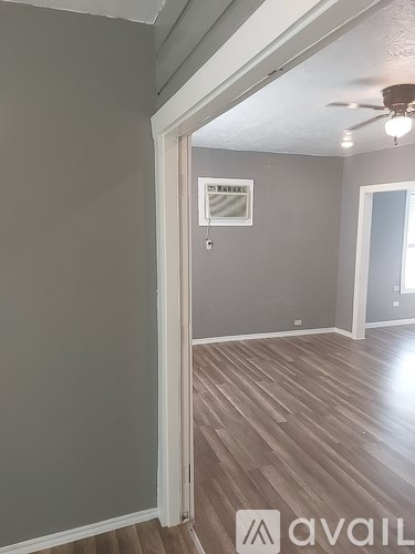 A room with a wooden floor and a ceiling fan.