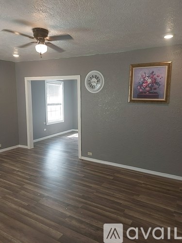 A room with a ceiling fan and a clock on the wall.