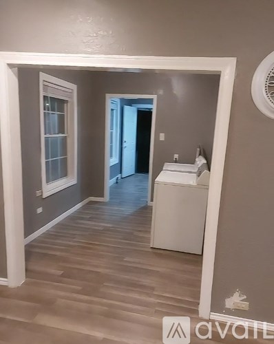 A bathroom with a white cabinet and wooden flooring.