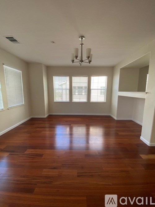 A room with wooden floors and a chandelier.