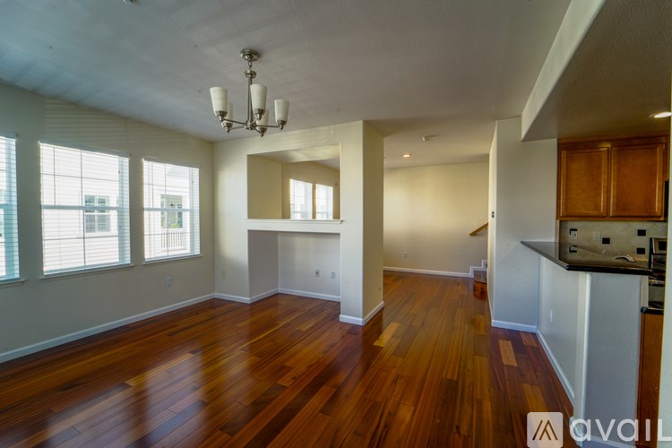 A large empty room with wooden floors and a chandelier.