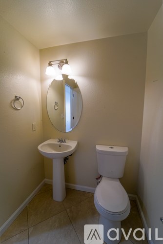 A bathroom with a toilet, sink, and mirror.