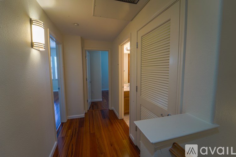 A hallway with a white bench and wooden floors.