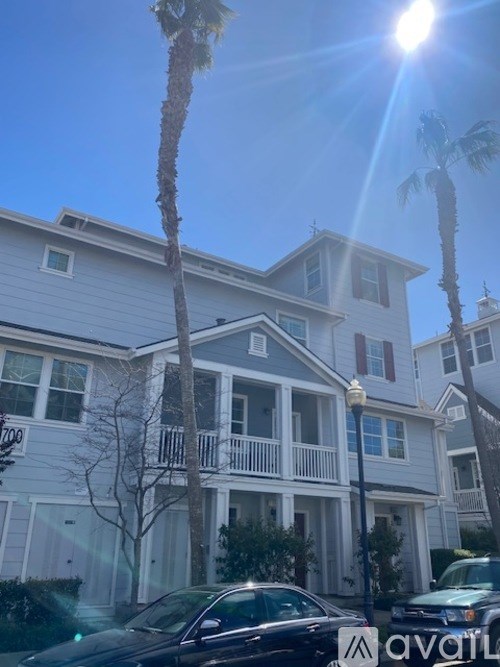 A sunny day in front of a two-story house with a car parked in front.