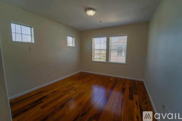 A room with wooden floors and two windows.
