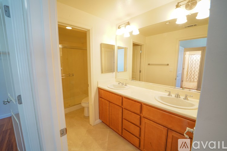 A bathroom with a vanity, mirror, and shower.