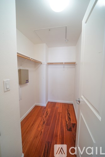 A hallway with wood floors and white walls.