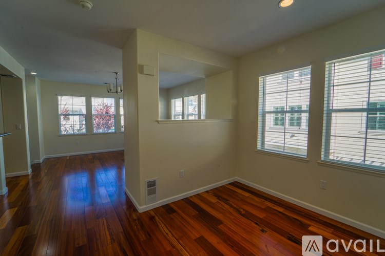 A room with wooden floors and a large mirror on the wall.