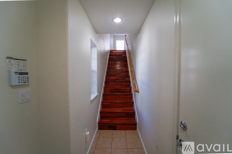 A long hallway with a staircase leading to a door.