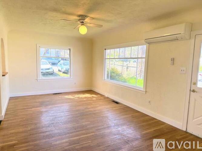 A room with wooden floors and a ceiling fan.