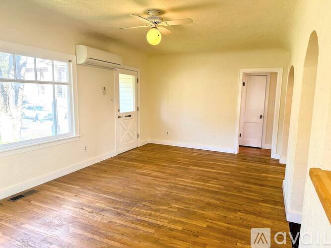 A room with wooden floors and a ceiling fan.